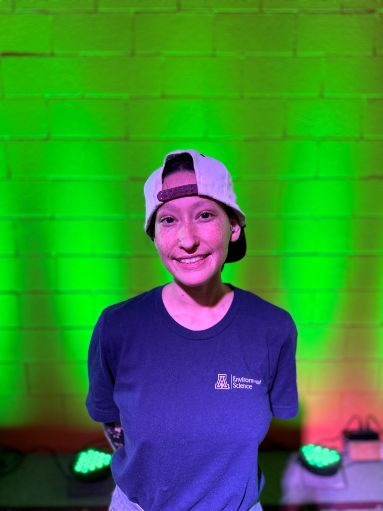 a photo of a person in a University of Arizona t-shirt in front of a brick background